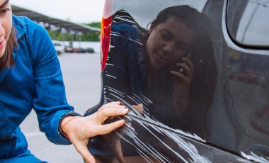 woman stand near scratched auto, call for help, parked car insurance guide