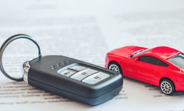 document of car insurance cover lost keys or stolen keys with small replica of car