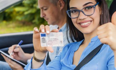 Girl holding new insurance ID card after switching car insurance from parents